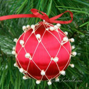 satin ornament ball enclosed in decorative netting with beads