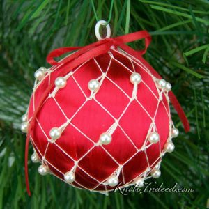 satin ornament ball enclosed in decorative netting with beads